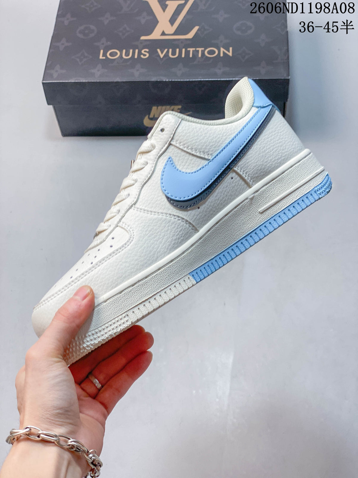 Side view of the cream-white low-top sneaker with a light blue Swoosh and outsole accents