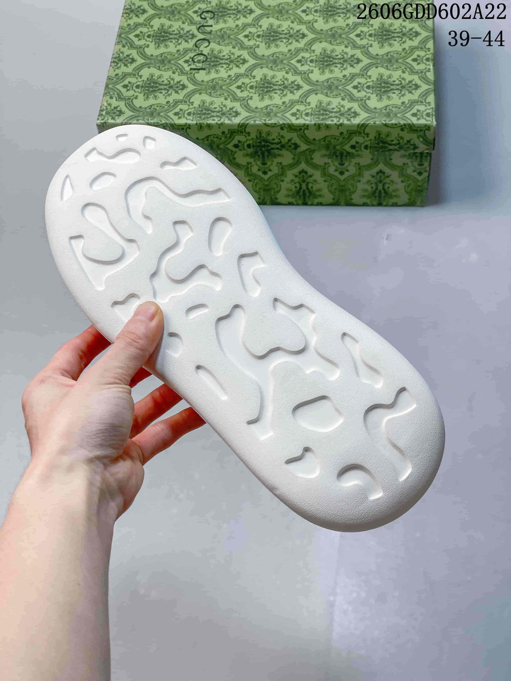 Underside of the white sneaker sole showing a molded tread pattern