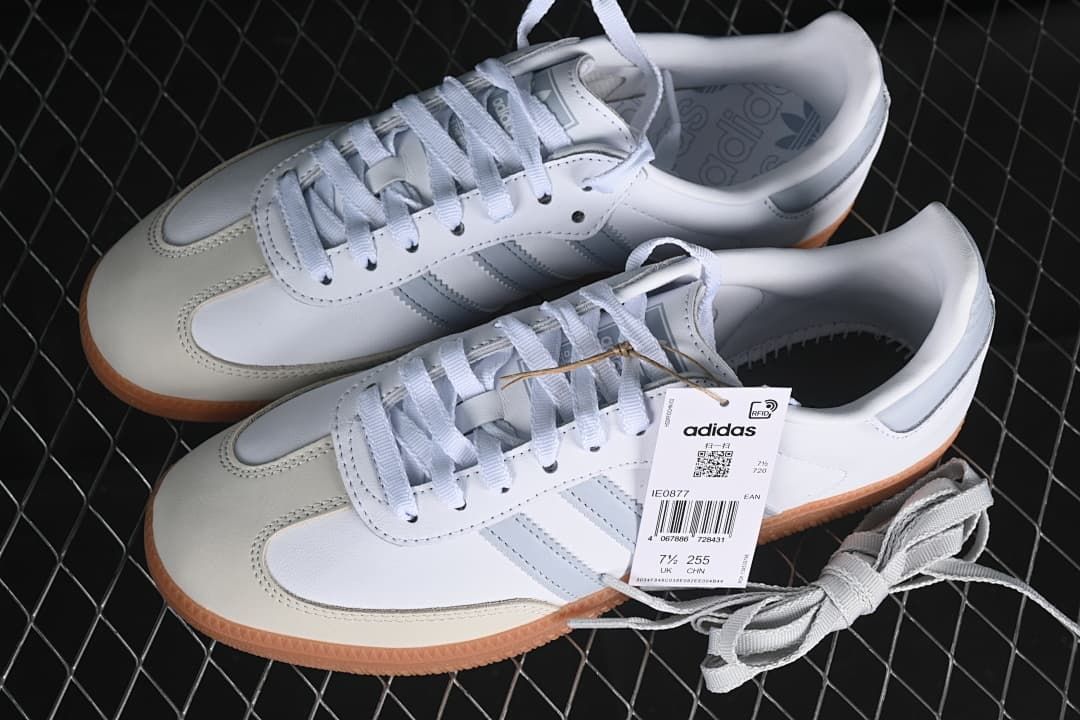 Pair of white and grey Samba OG sneakers with gum soles and product tag