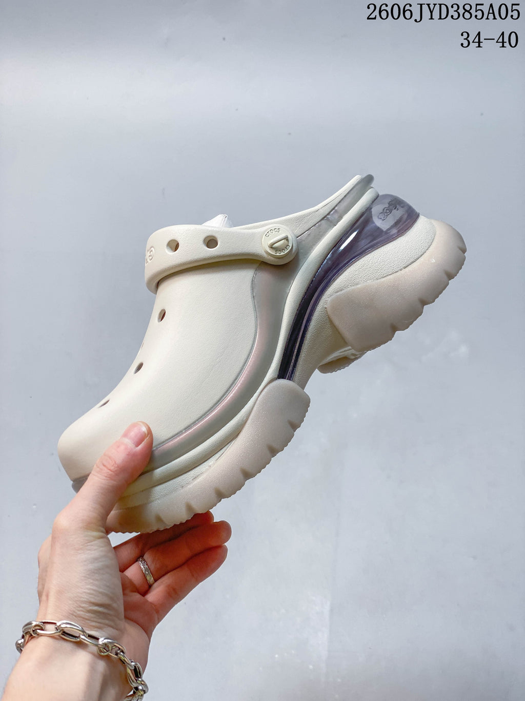 Side view of an ivory clog with a translucent accent and chunky sole