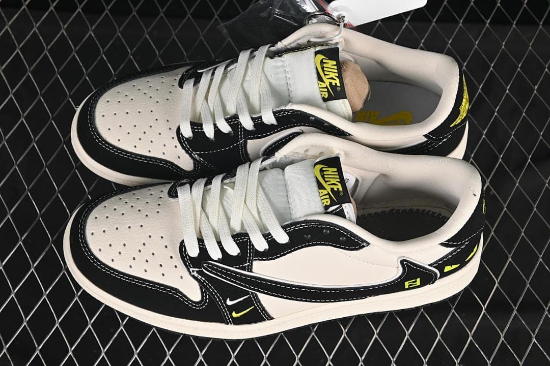 Pair of off-white and black low-top sneakers with perforated toes, white laces, and yellow accents, viewed from above.