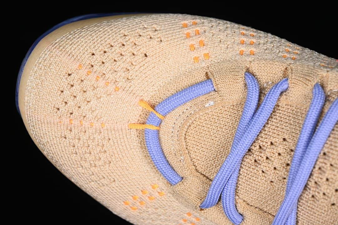 Close-up of the knit toe box with orange accents and lavender laces.