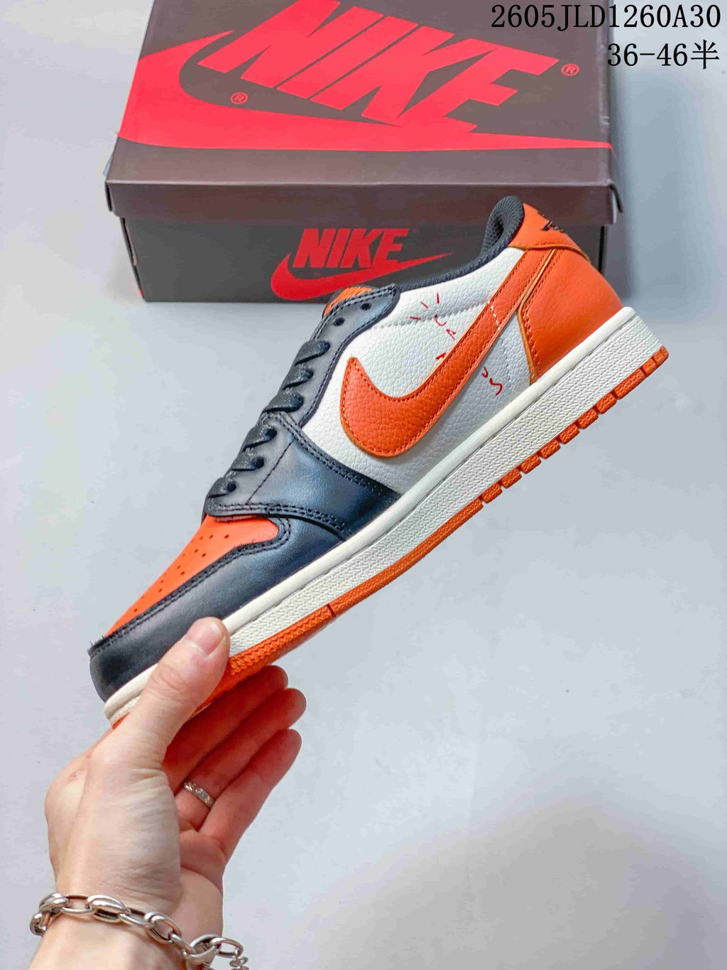Side view showing the orange Swoosh, white panel, and charcoal overlays