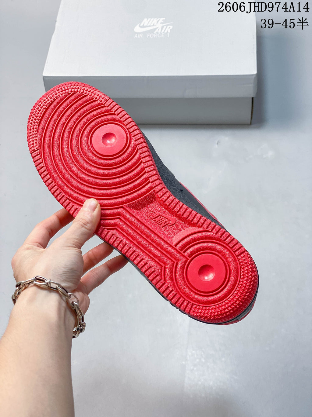 Bright red outsole with circular tread patterns on a low-top sneaker