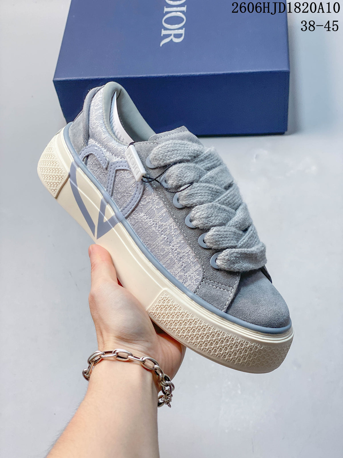 Angled side view of a gray sneaker with a large side motif and textured sole