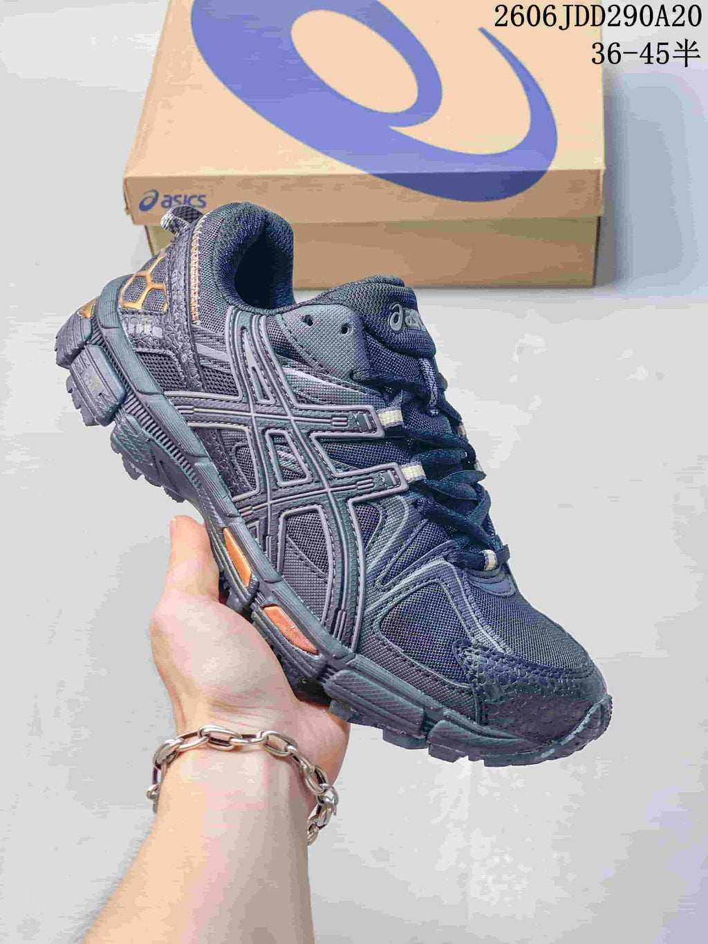Close-up of a dark gray ASICS Gel-Kahana 8 sneaker with orange accents.