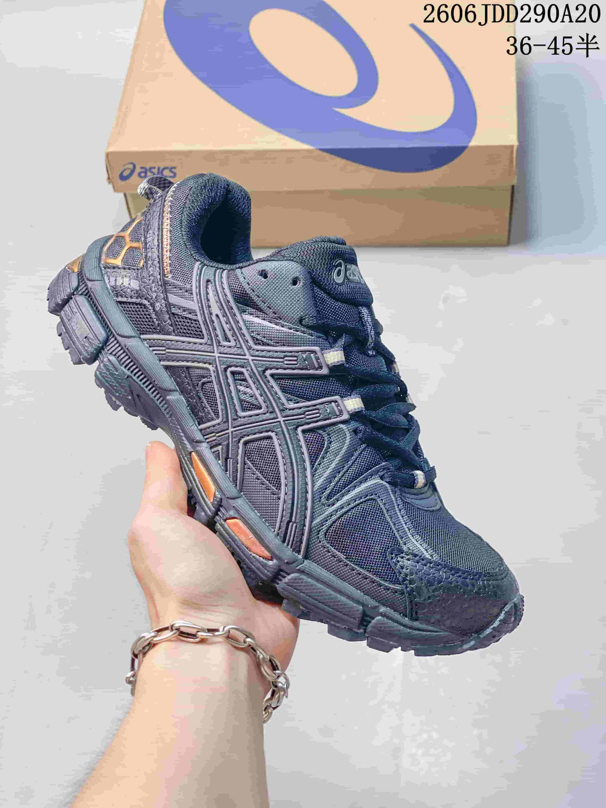 Close-up of a dark gray ASICS Gel-Kahana 8 sneaker with orange accents.