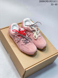 Pair of pink New Balance-style low-top sneakers with contrasting laces, shown on a box