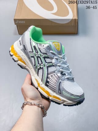 ASICS low-top sneaker with bright green lining and yellow outsole accents, shown with a branded shoe box.