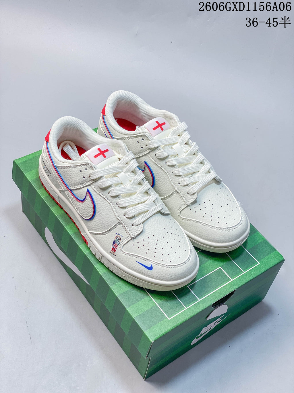 Pair of off-white Nike Dunk low-top sneakers with red and blue details, shown on a green football-themed box.