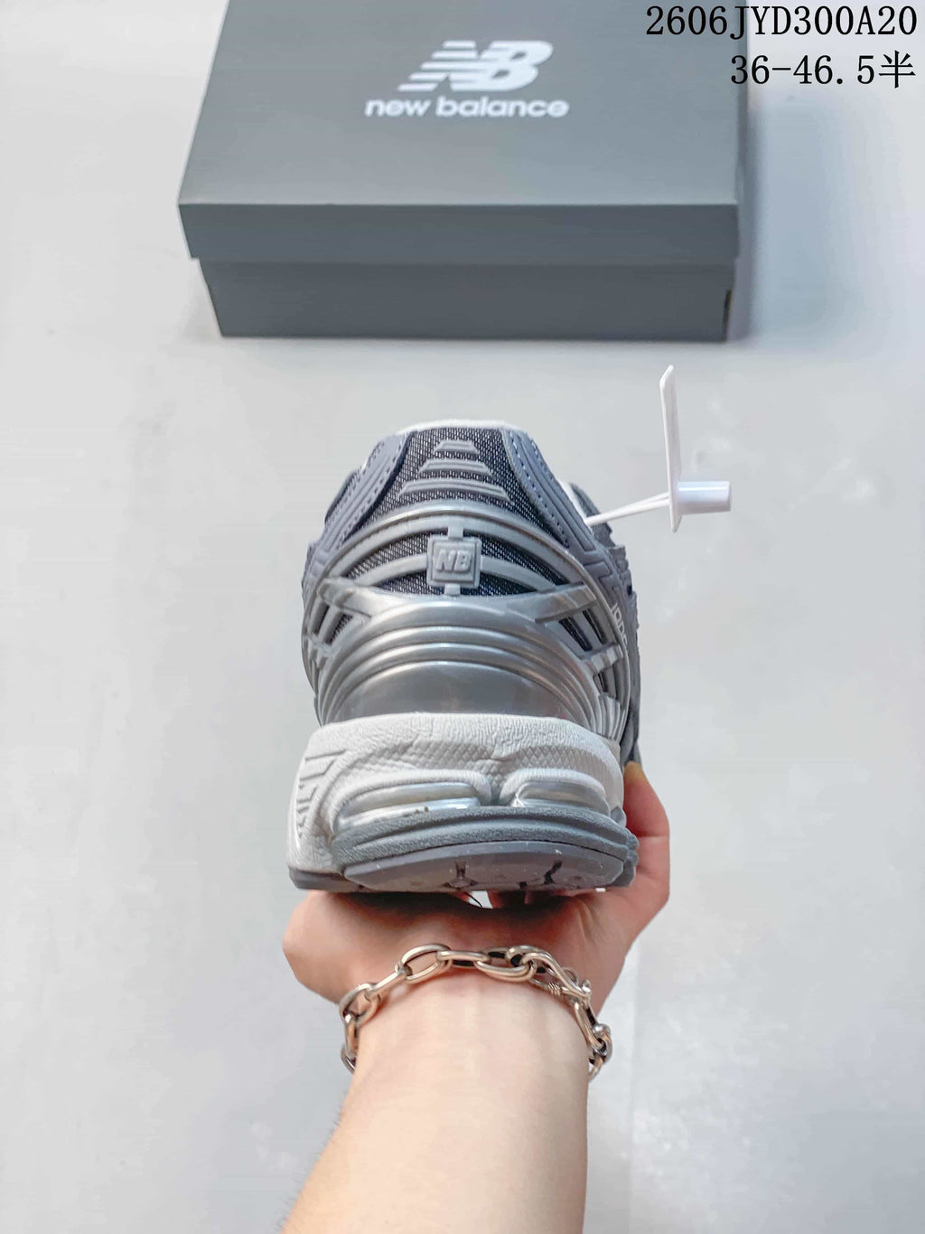 Rear view showing the heel and sole of a grey New Balance 1906 sneaker