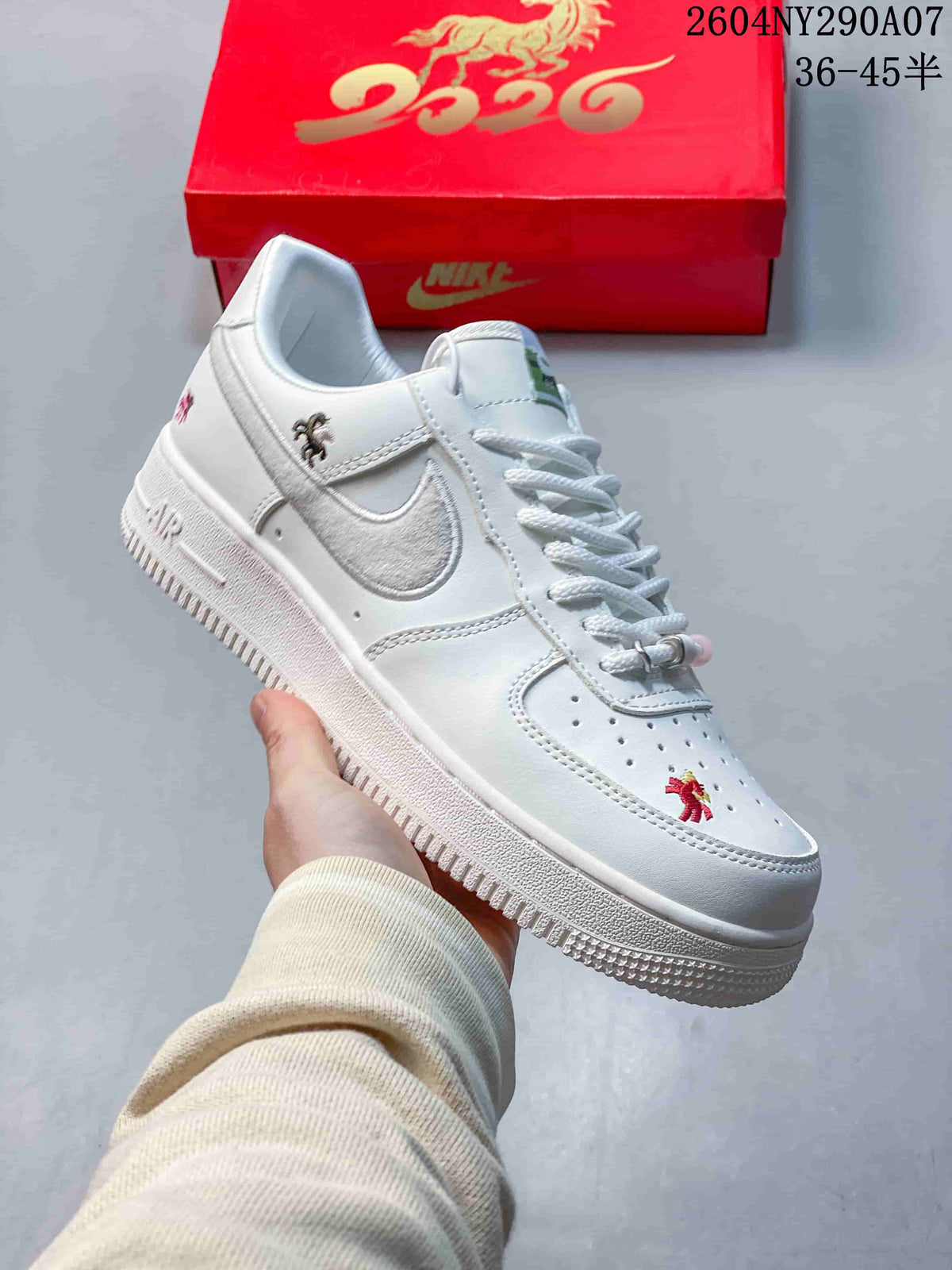 Side view of a white low-top sneaker with embroidered decorations.