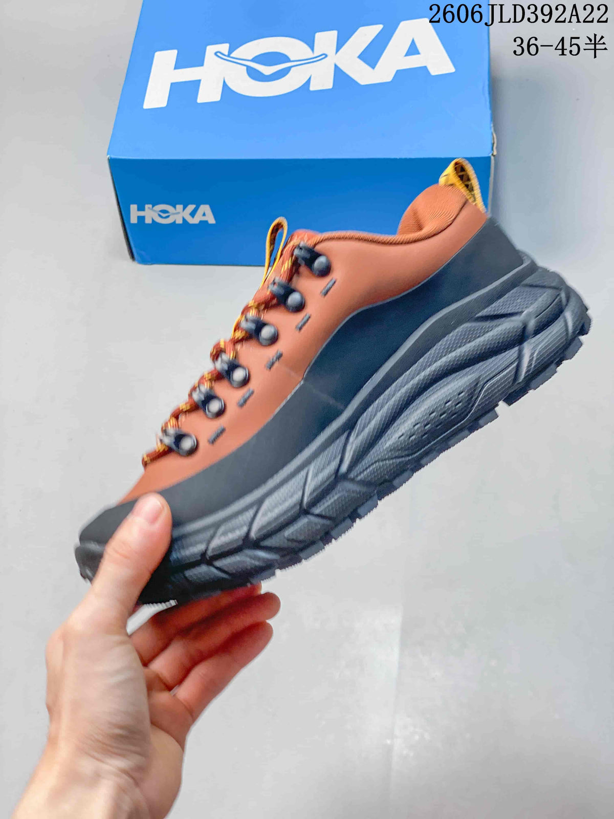 Side view of the rust-orange and charcoal HOKA Tor Summit shoe