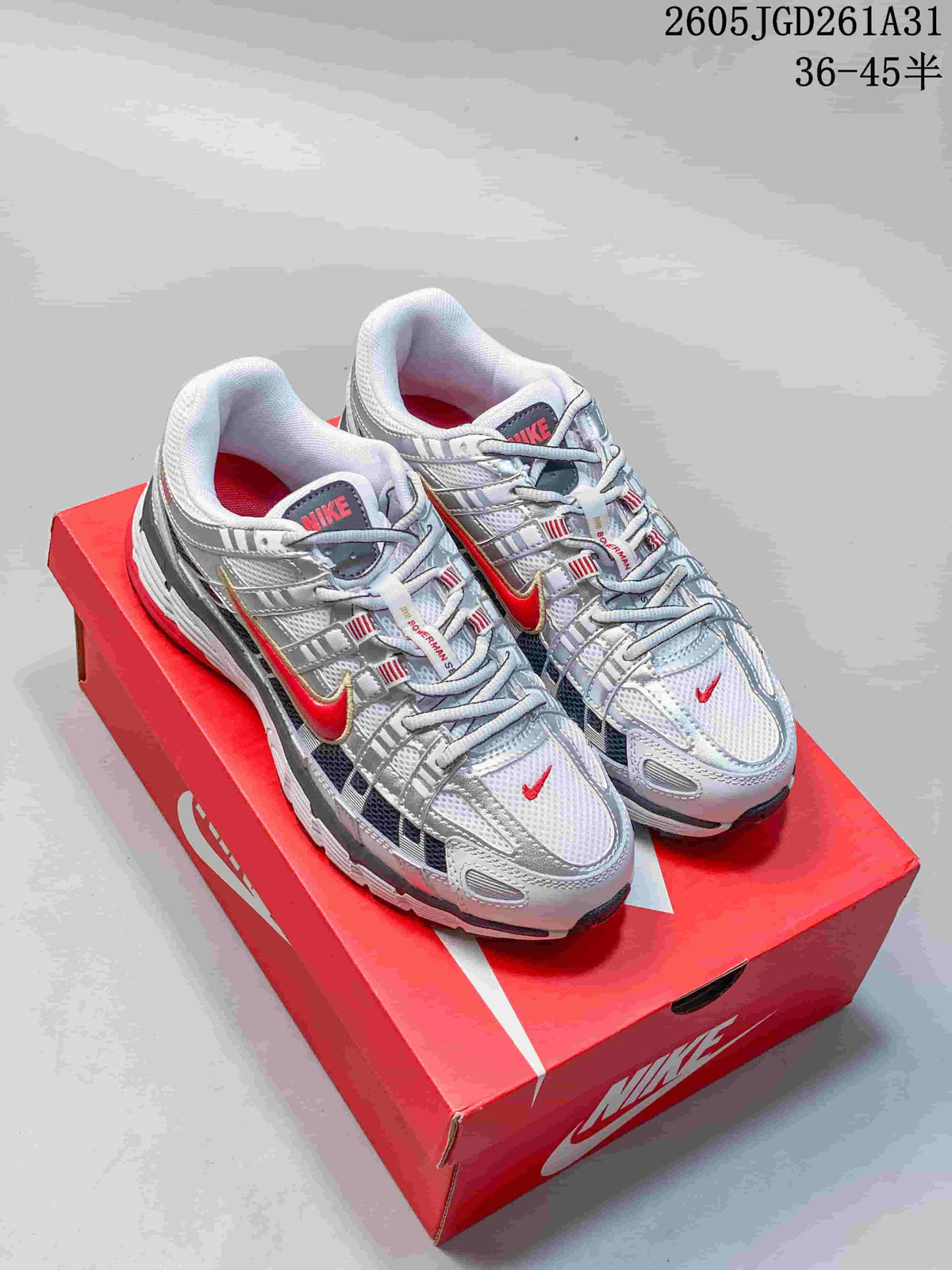 White Nike P-6000 sneakers with red, gray, and dark accents, shown on a red shoebox.