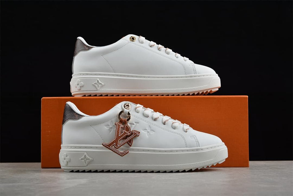 White platform sneakers displayed against an orange box