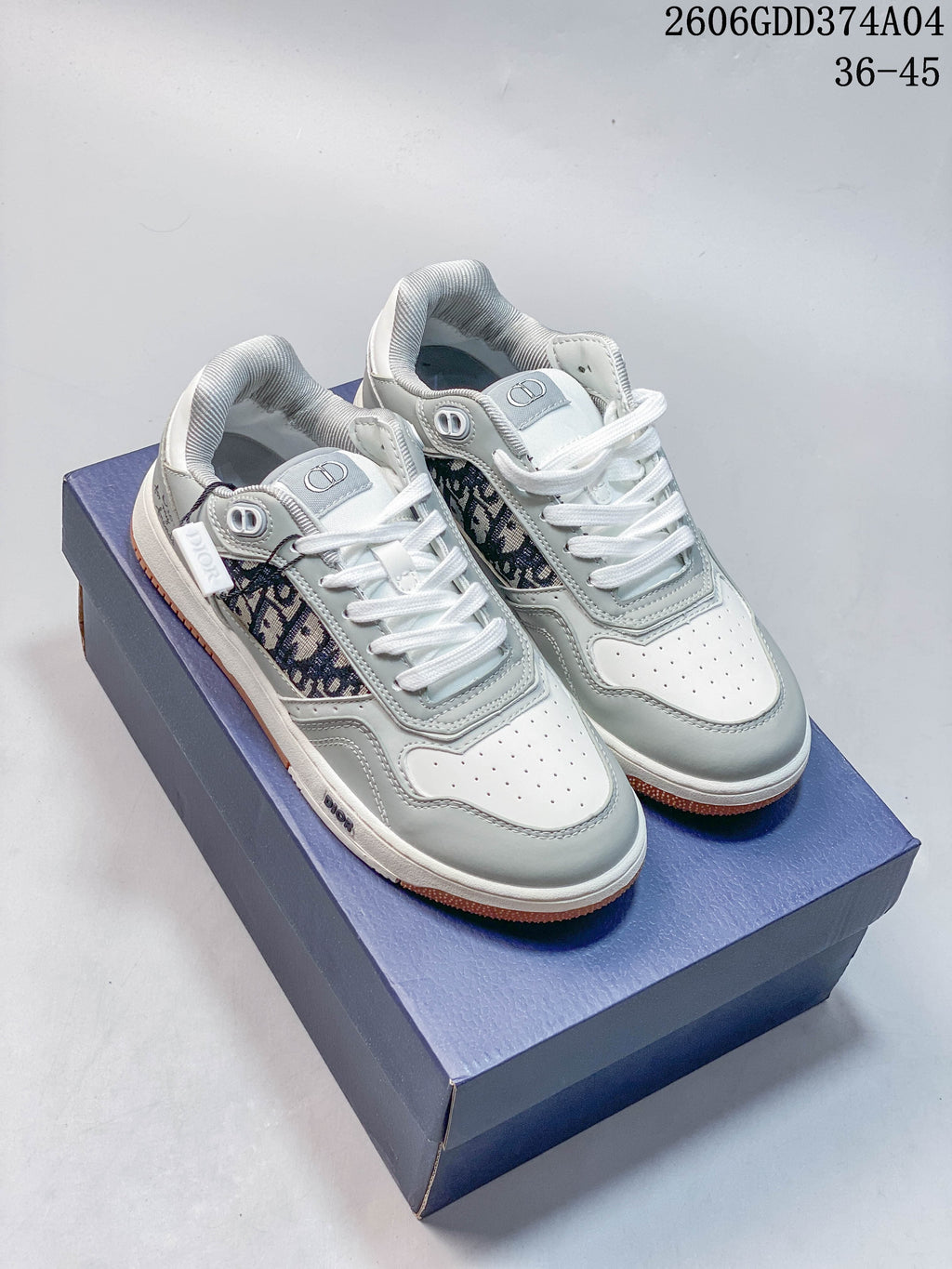 Gray and white Dior low-top sneakers with patterned side panels, shown from above