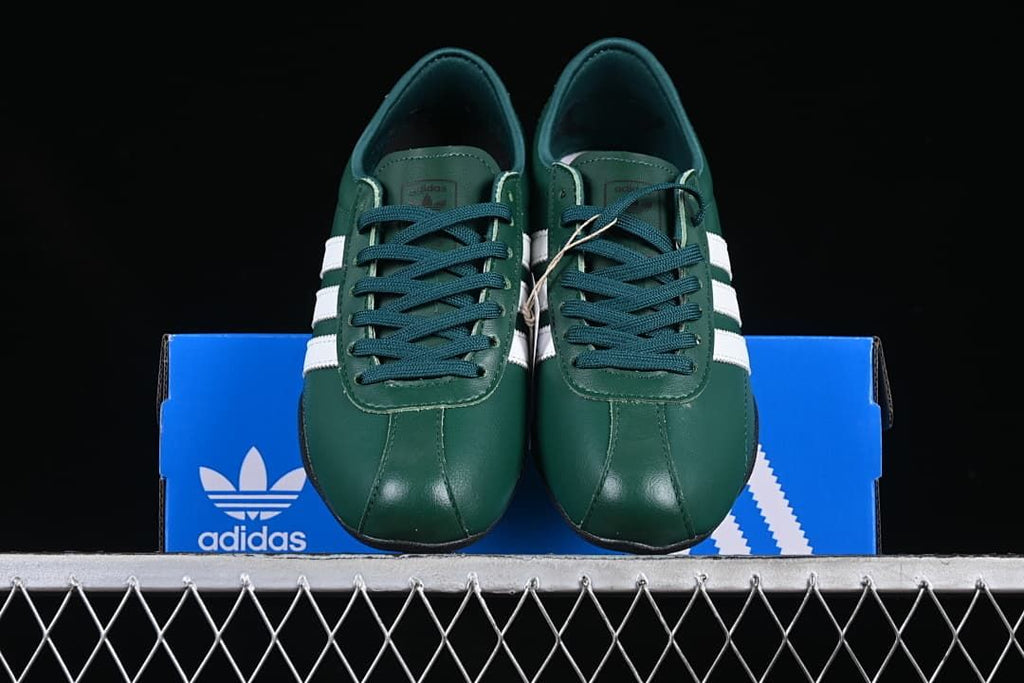 Front view of the pair showing the green toes, dark laces and white side stripes.