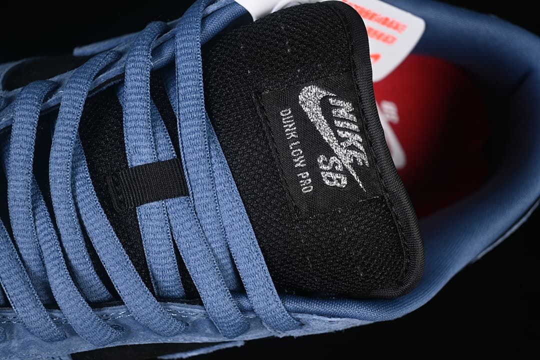 Close-up of the black tongue with Nike SB Dunk Low branding and blue laces