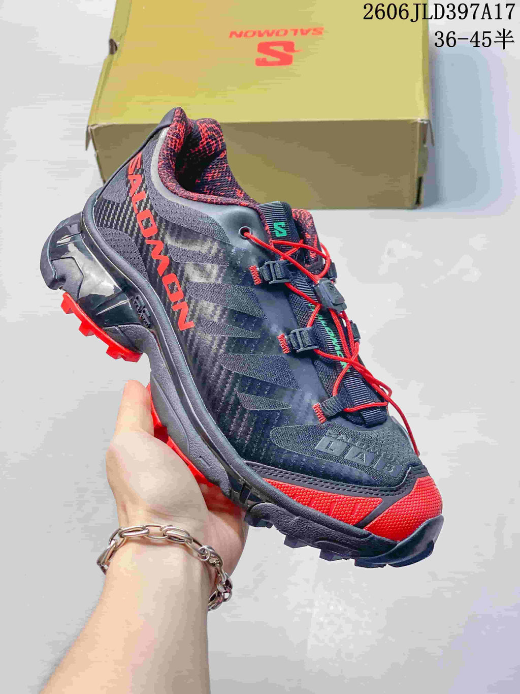 Angled side view of the shoe with dark gray panels, red detailing and prominent tread