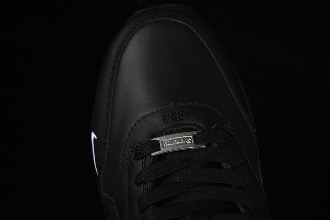 Top-down detail of black laces and a metal lace ornament