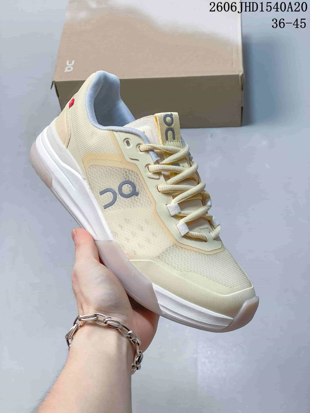 Angled side view showing the cream upper, On logo and white sole