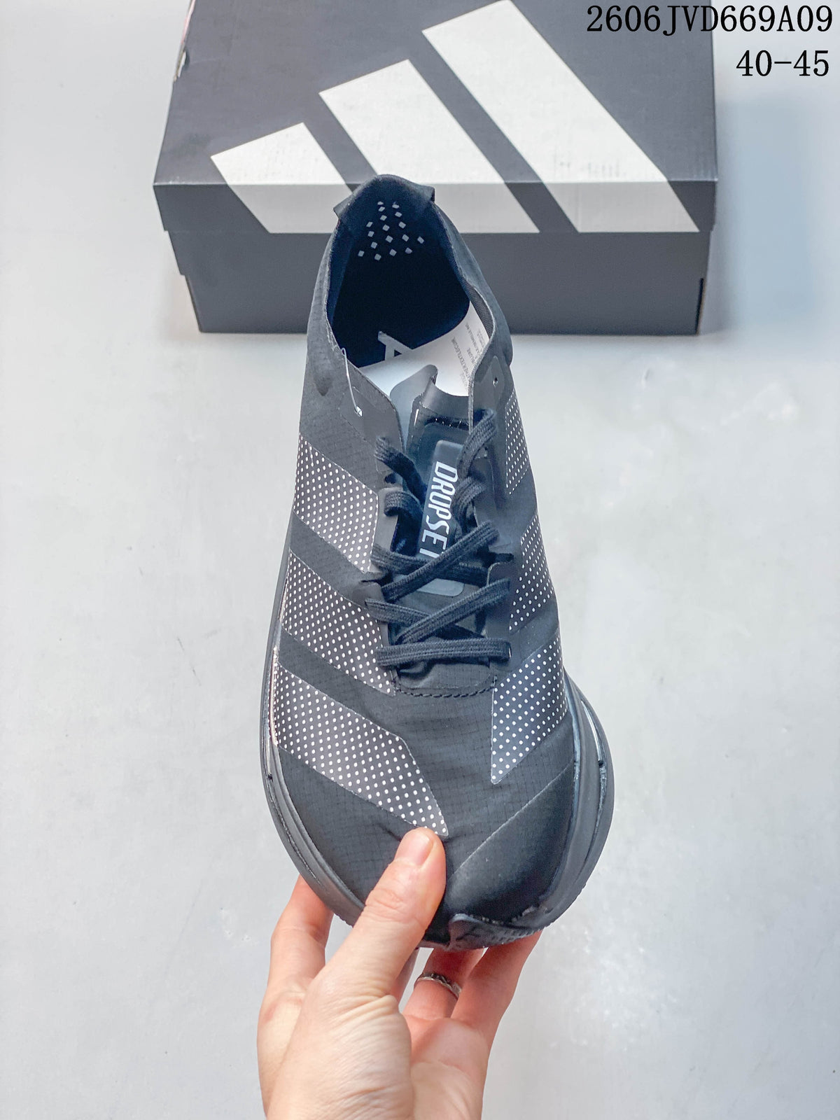 Top view of a dark gray Adidas shoe showing its laces and dotted panels