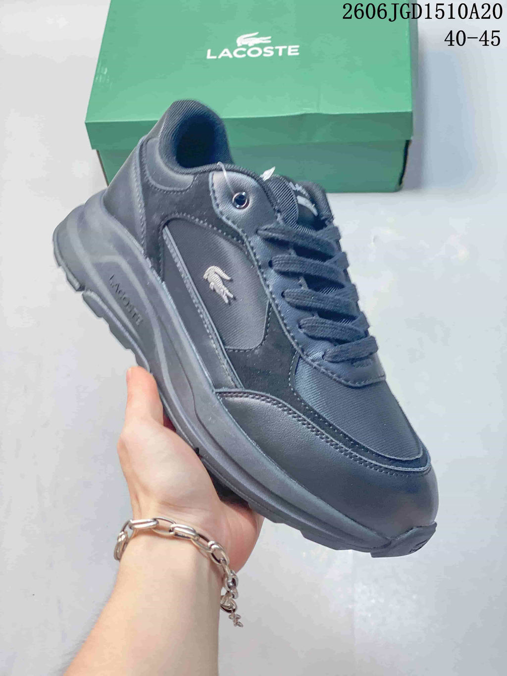 Angled side view of a dark navy Lacoste sneaker with a crocodile emblem.