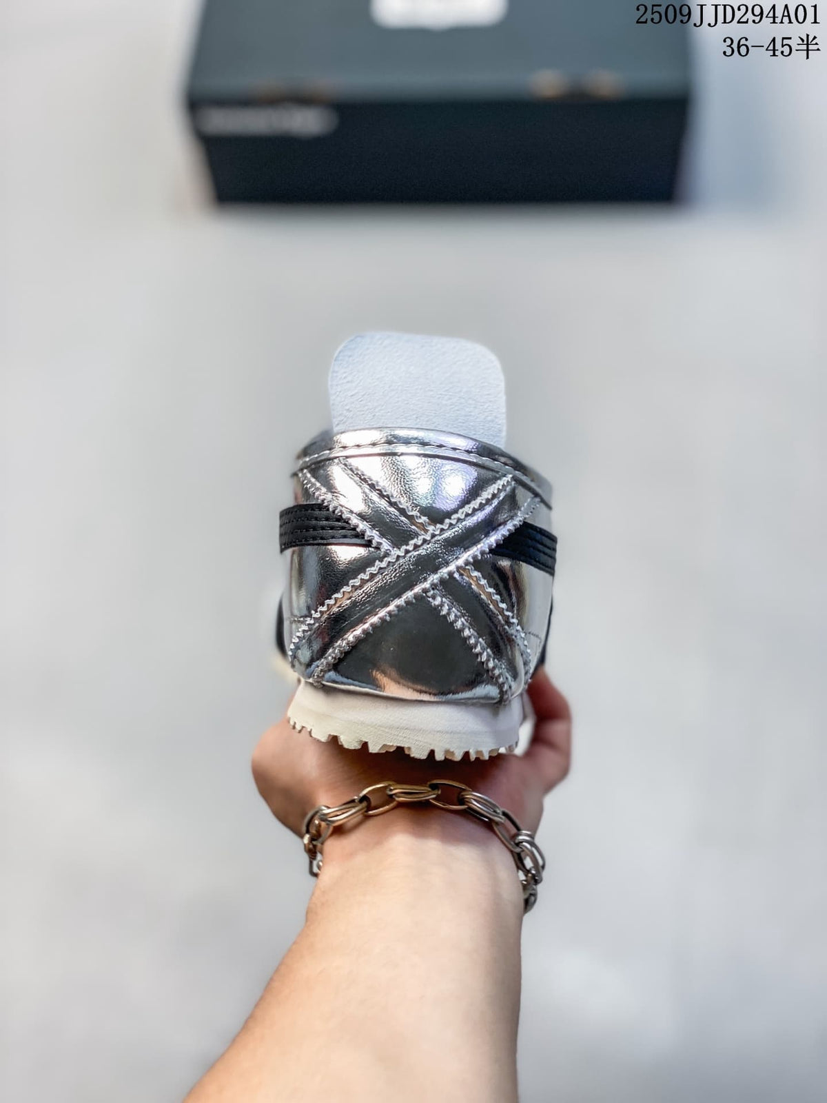 Rear view of the silver sneaker showing stitched heel panels and dark stripes.