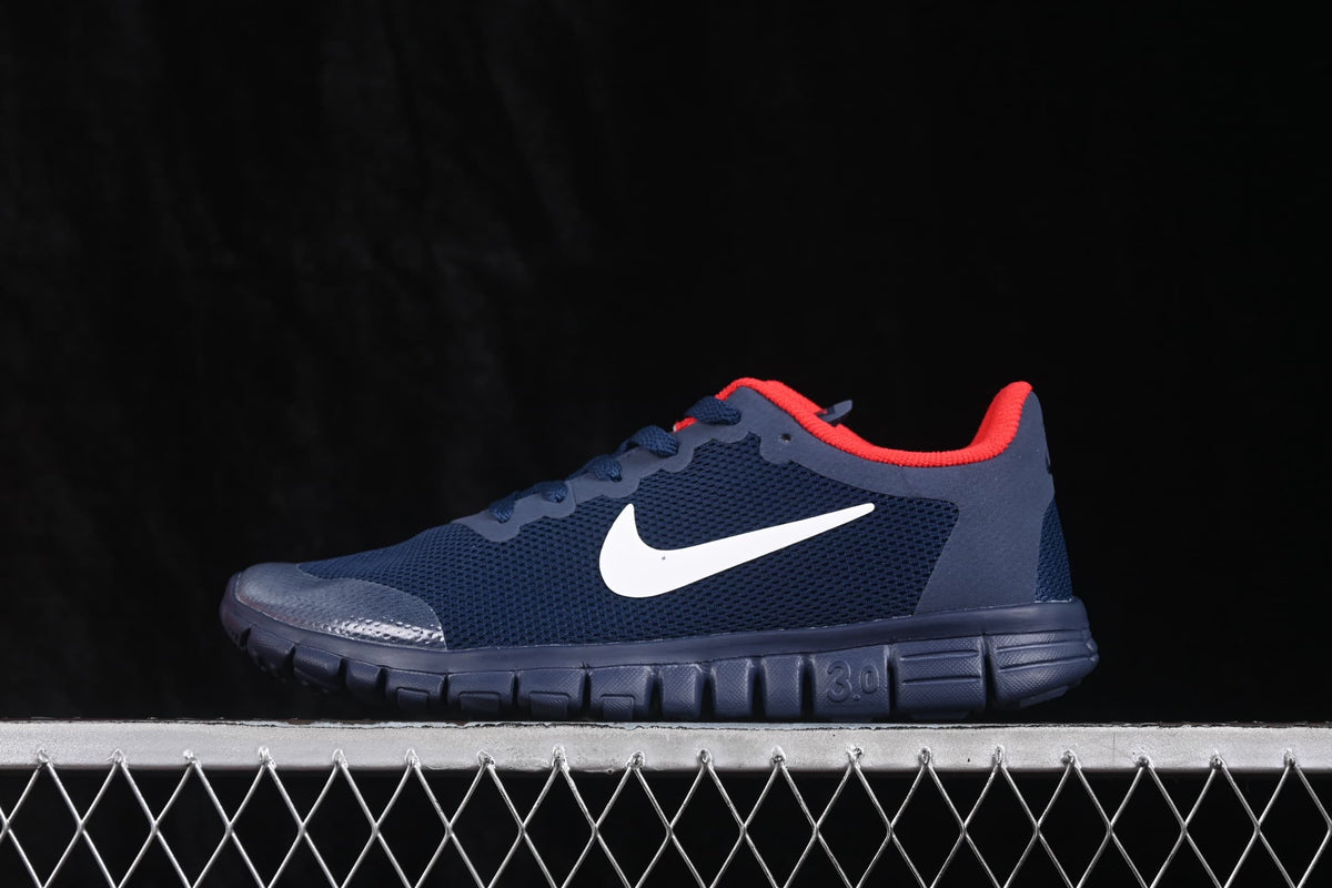 Side profile showing the navy low-top upper, white Swoosh, red collar lining, and flexible segmented outsole.