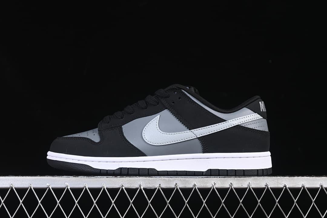 Side view of black, grey, and white Nike SB Dunk Low sneakers