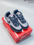 Pair of gray and black Nike Air Max Waffle SP sneakers on a red shoebox