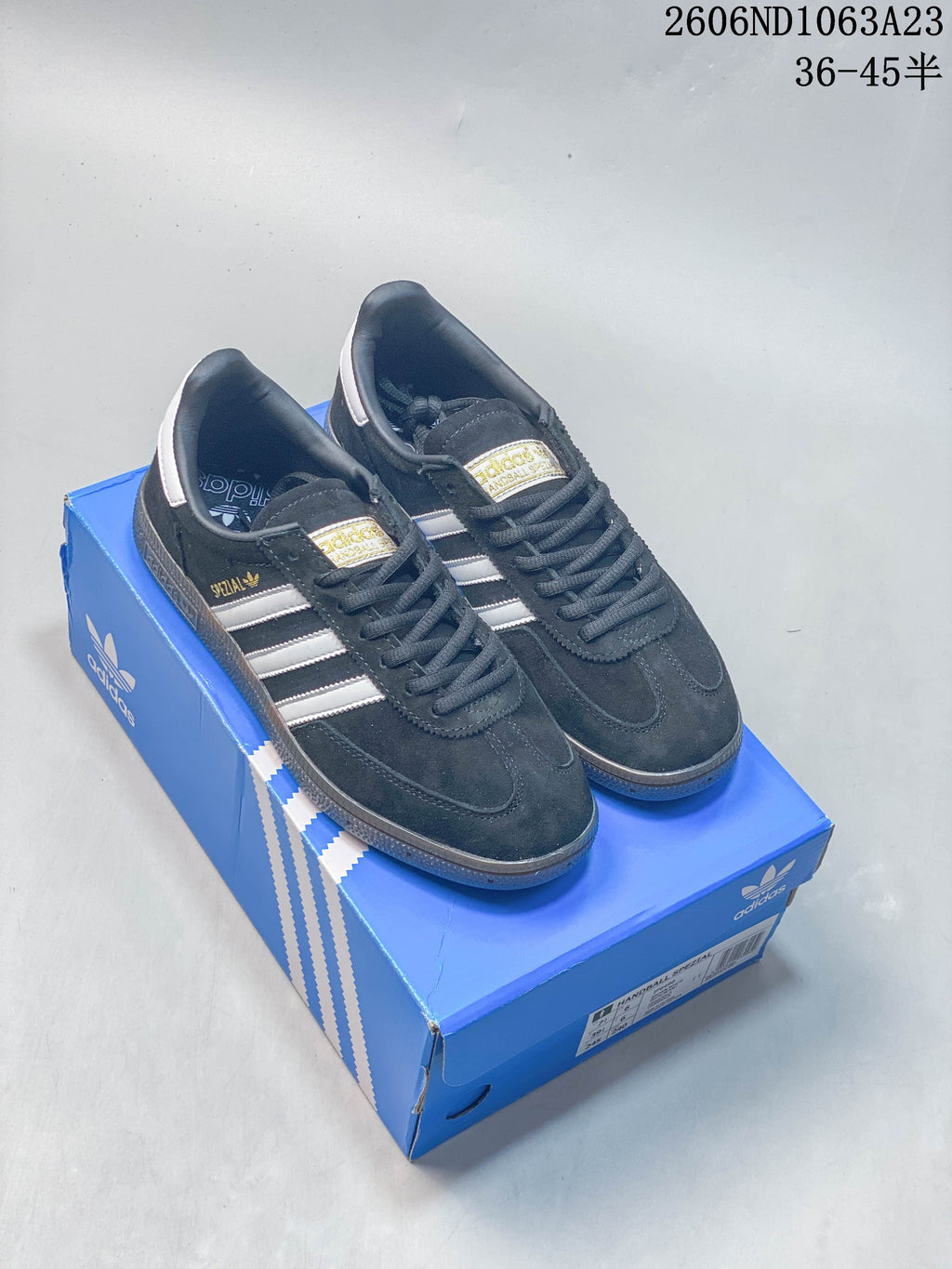 Navy and white Adidas Originals Samba Vegan OG sneakers shown on a blue box