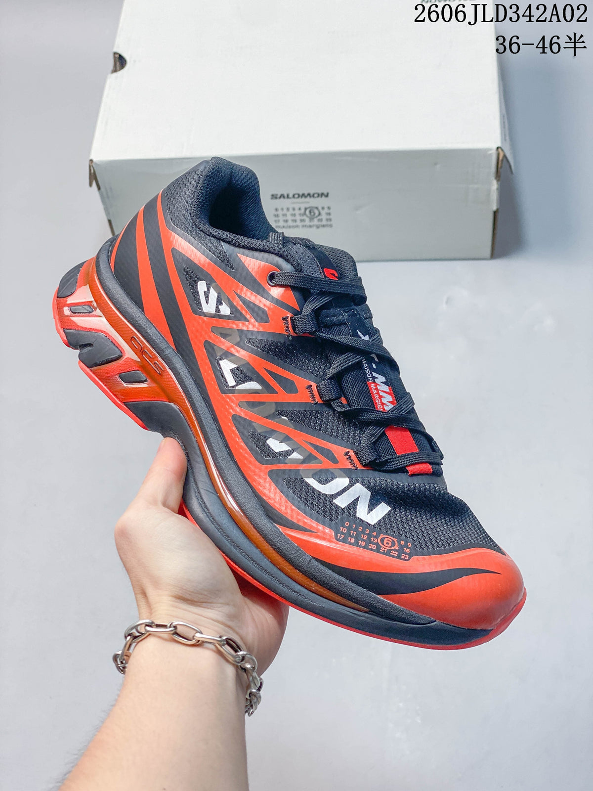 Angled side view of the navy and orange Salomon trail shoe.