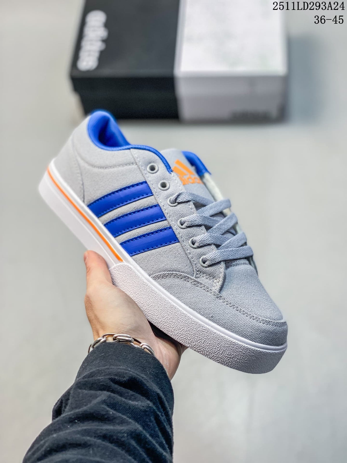 Close-up side view of a gray sneaker with blue stripes and orange accents