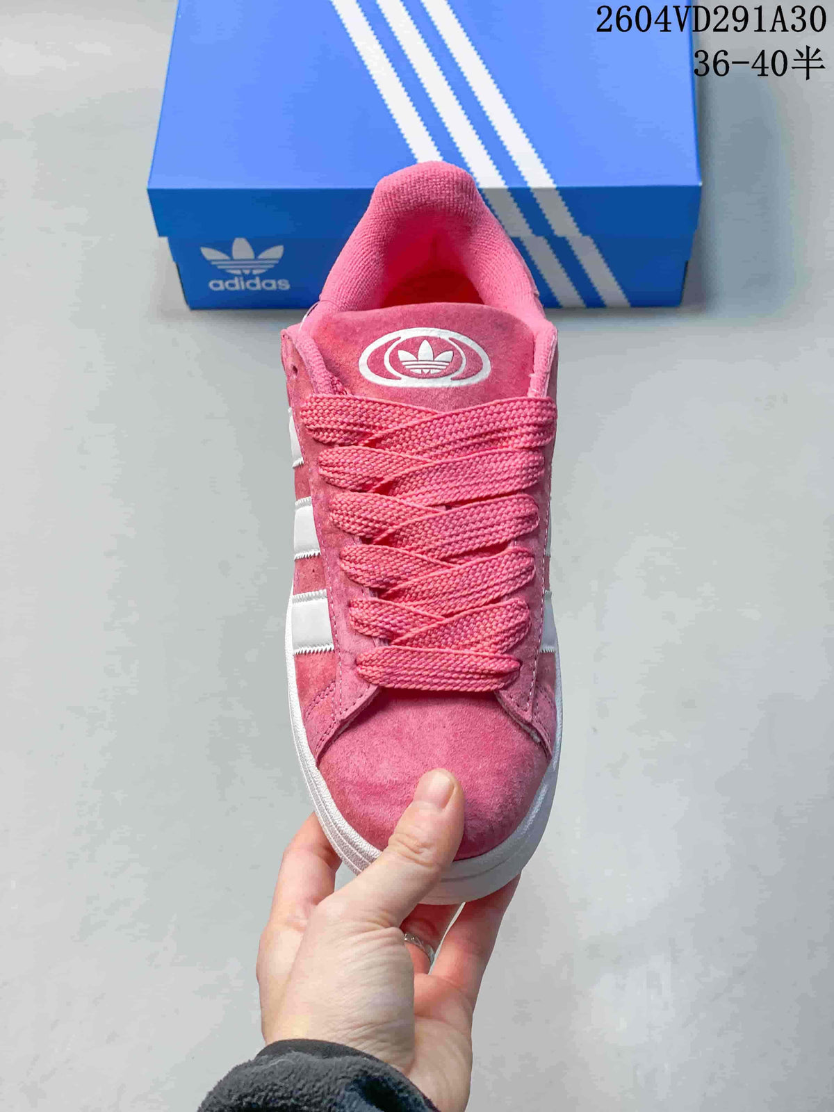 Front view of the pink sneaker with matching laces and white side stripes.