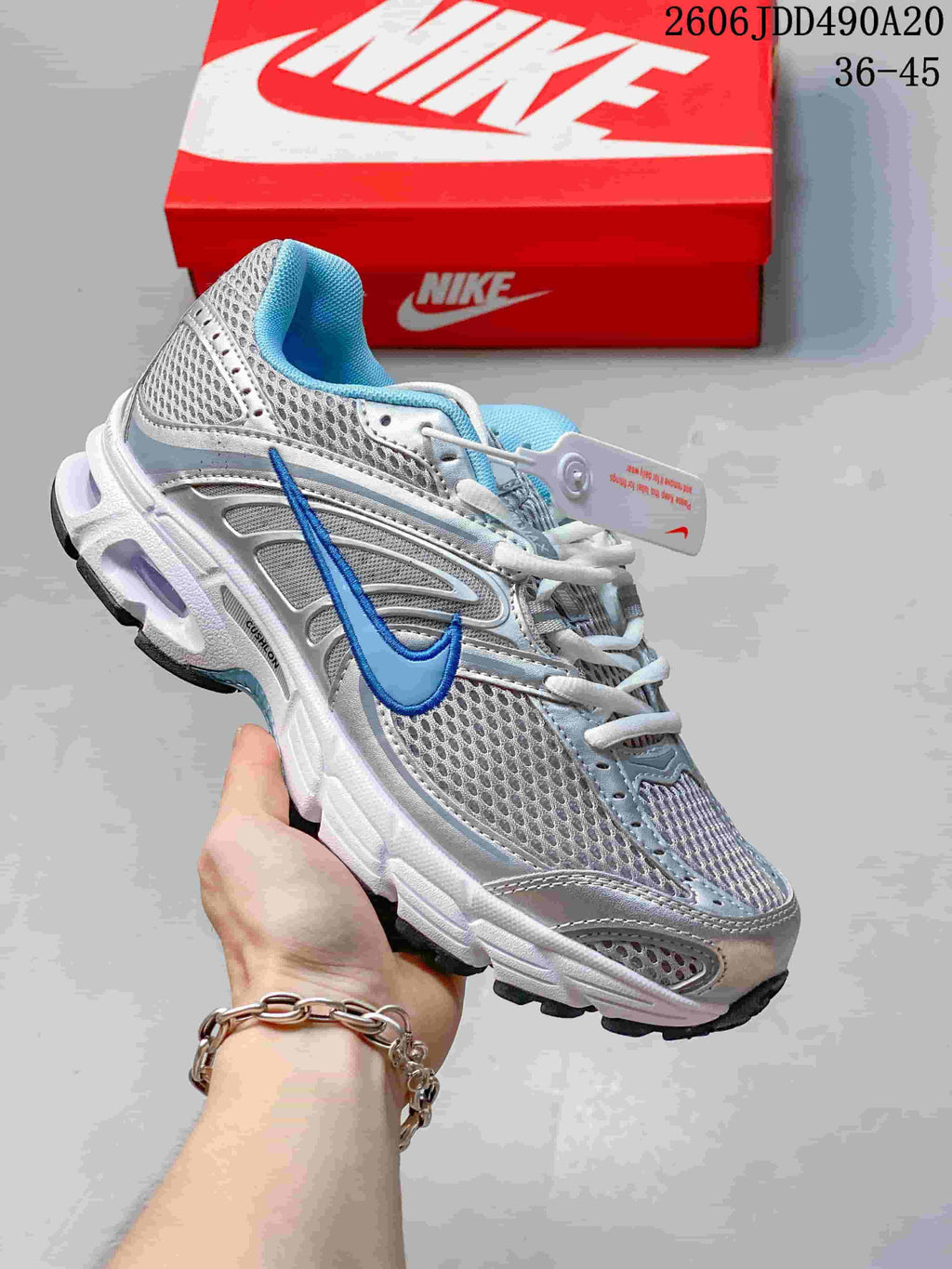Silver and white Nike Air Max Moto 2K sneaker with blue accents