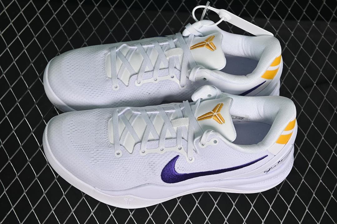 Pair of white Kobe VIII Protro basketball shoes with purple and yellow accents