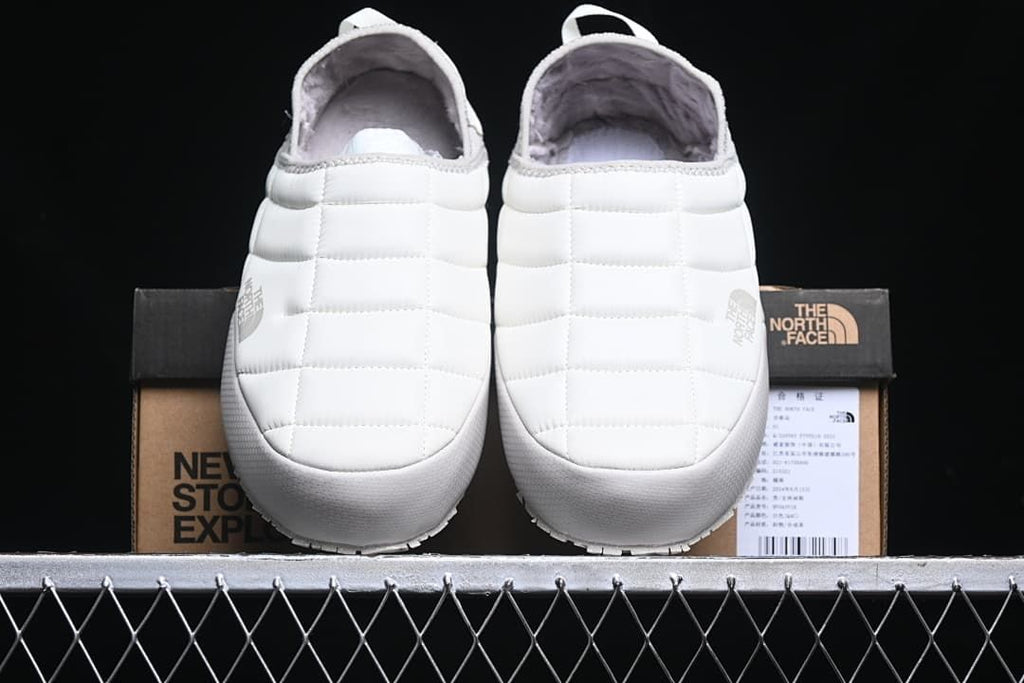 Front view of the pair of white mule slippers with plush lining.