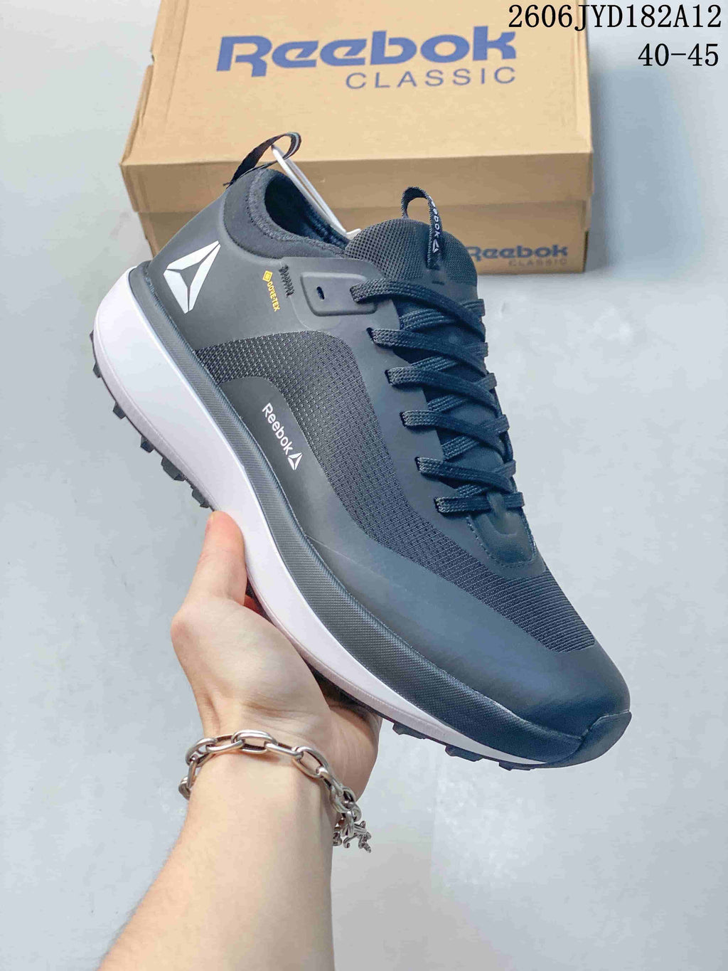 Side view of a dark gray Reebok sneaker showing its textured panels and branding