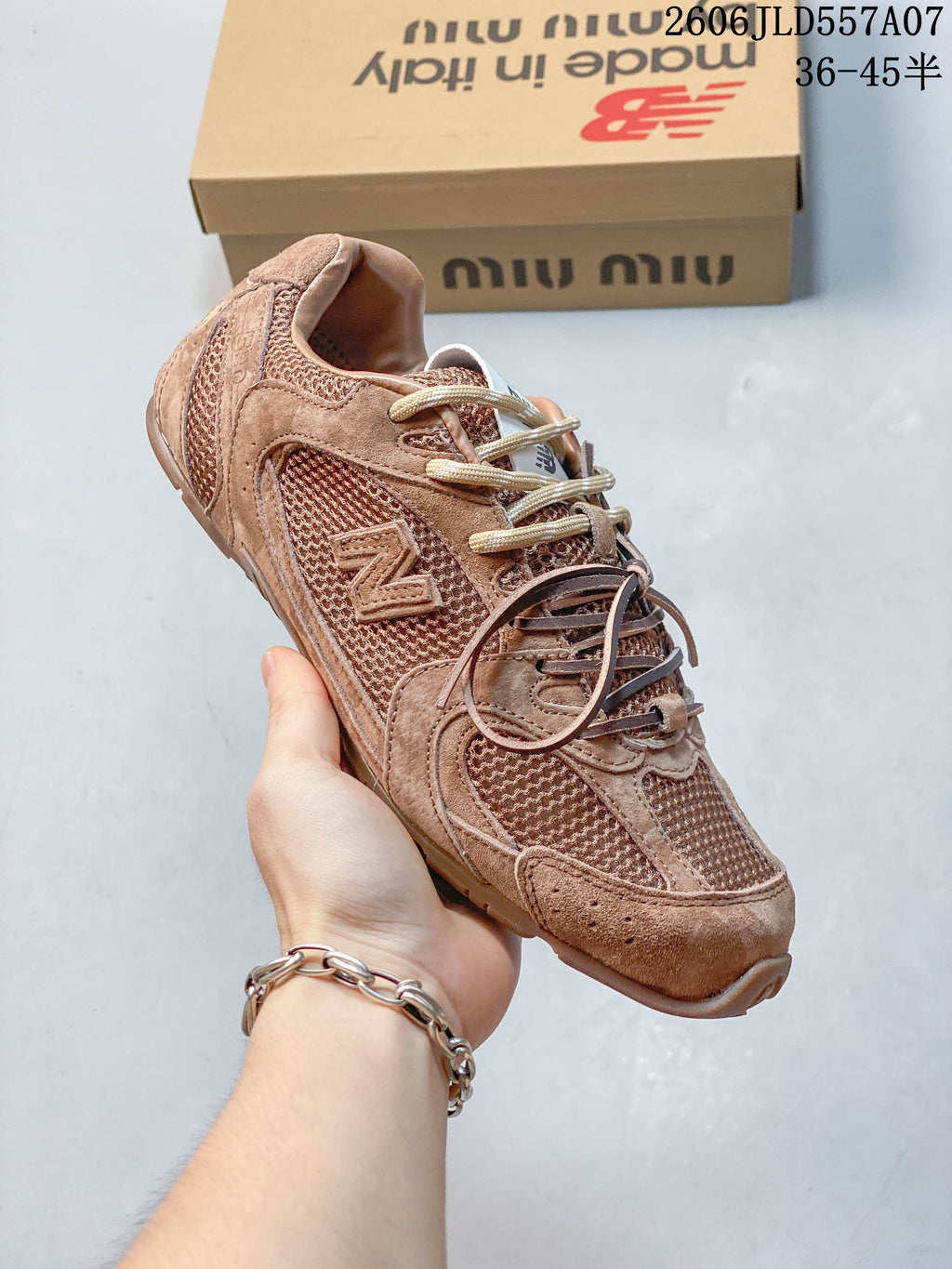 Angled view of the brown-toned sneaker with mesh panels and layered overlays.