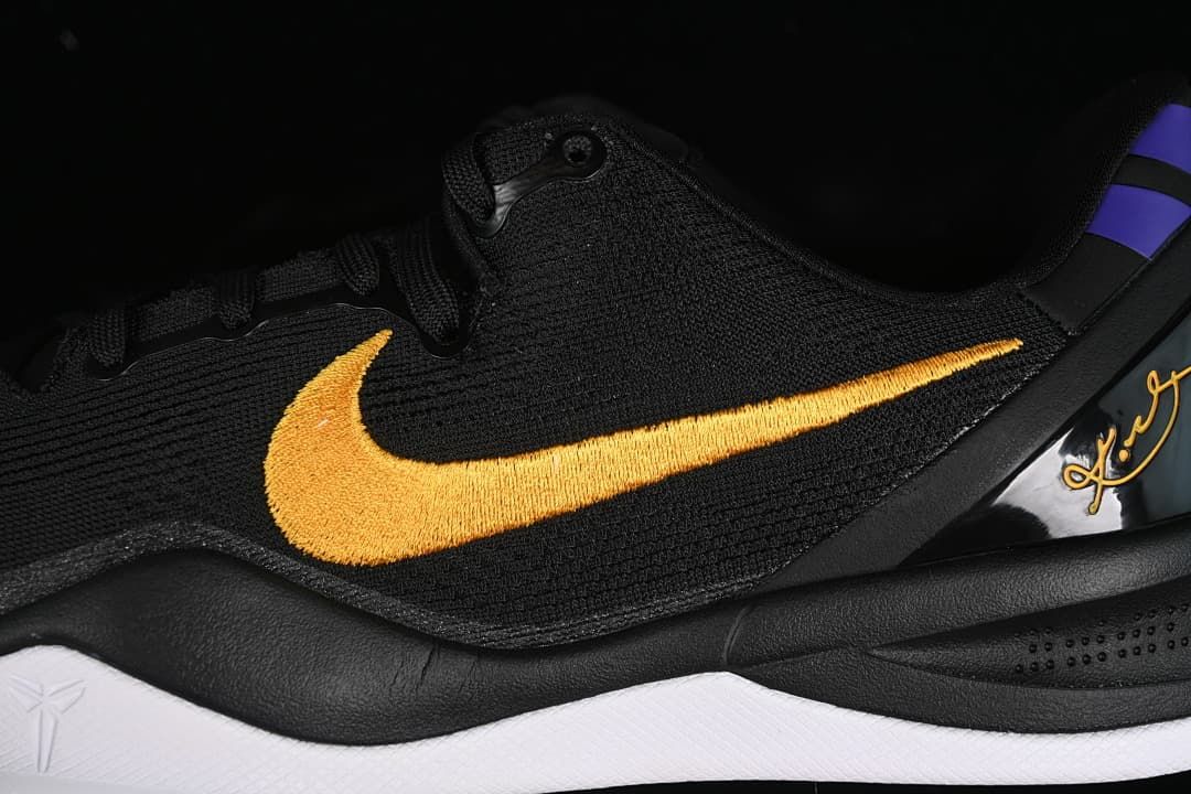 Close-up of gold Swoosh embroidery and black upper