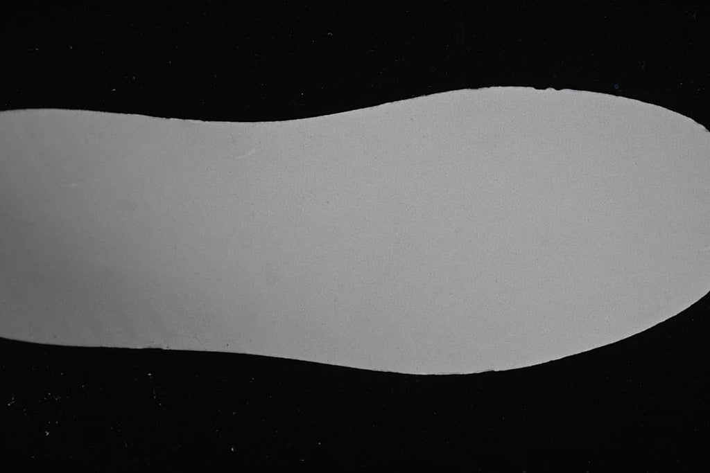 Close-up of a light-colored shoe sole against a dark background
