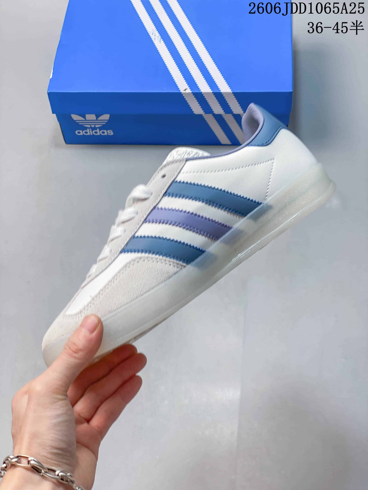 Side view of a white and light-gray sneaker with blue and lavender stripes.