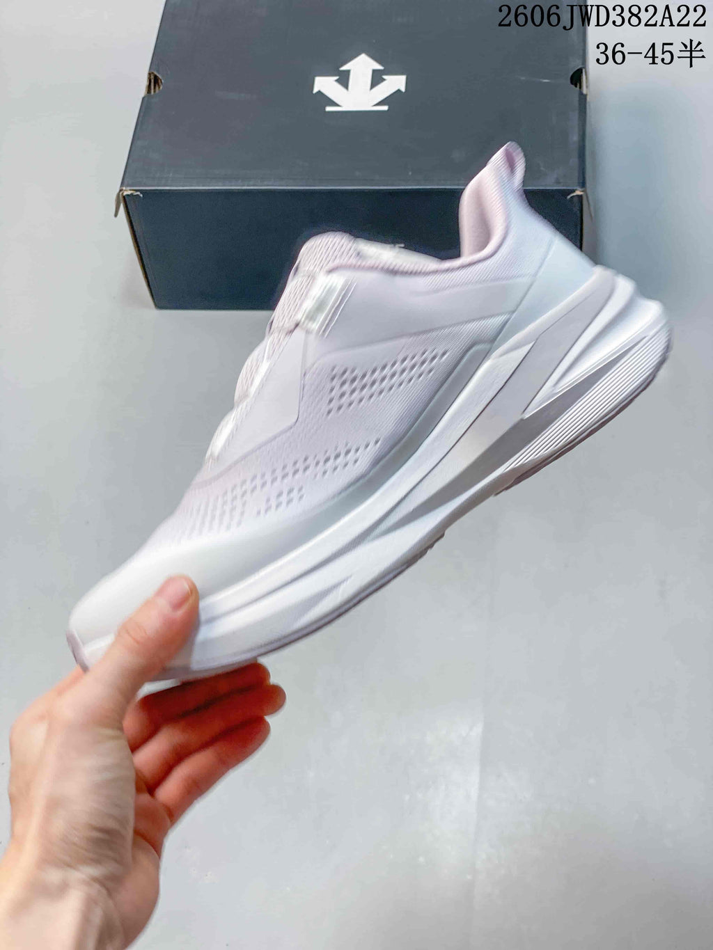 Side profile of the white and pale lavender DESCENTE running sneaker