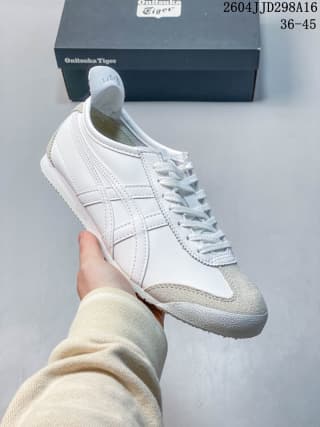 Angled front view showing the white laces, silver side stripes and contrasting toe panel of the ASICS Tiger Mexico 66 sneaker.