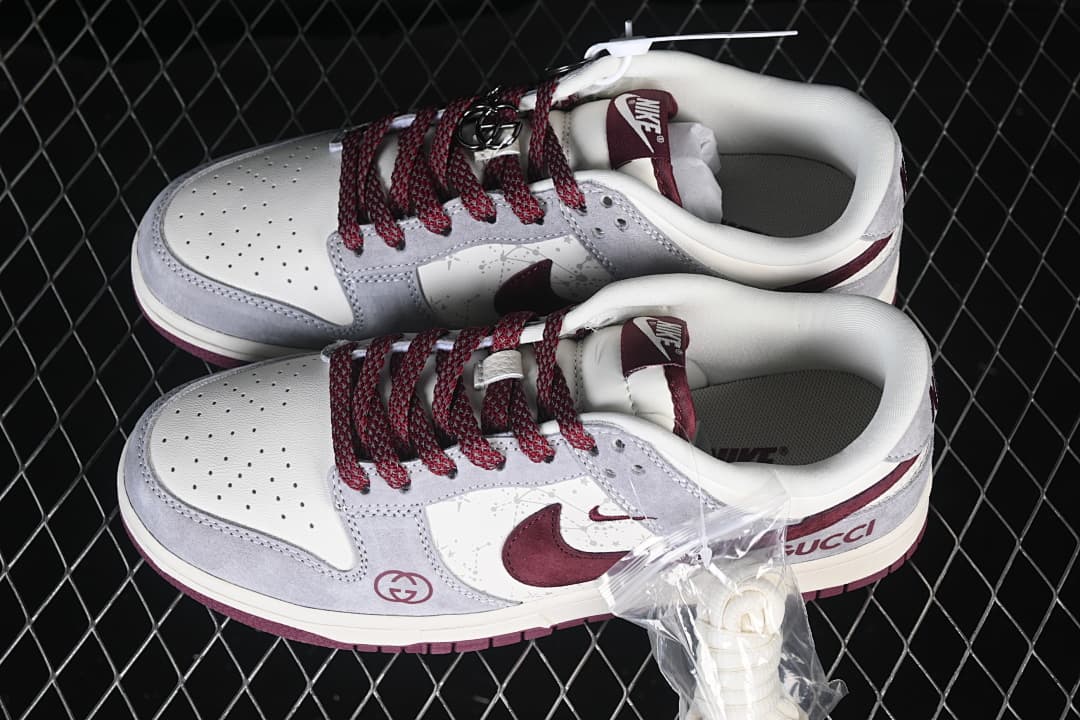 Pair of gray, white, and burgundy Nike SB Dunk Low sneakers shown from above