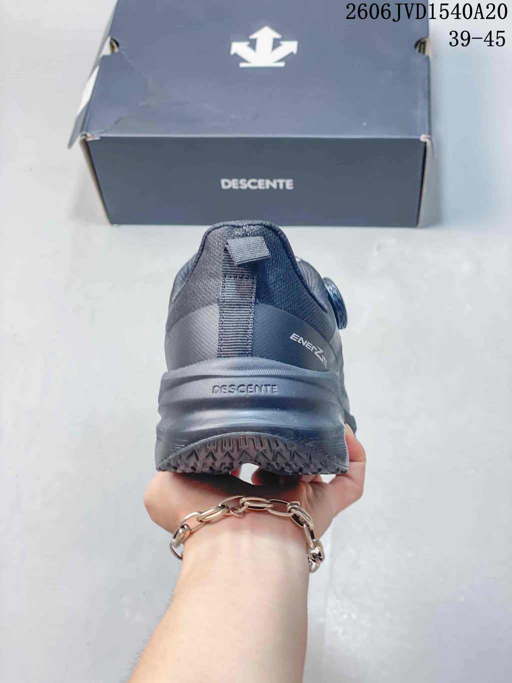 Rear view of a charcoal gray Descente sneaker showing the heel and outsole