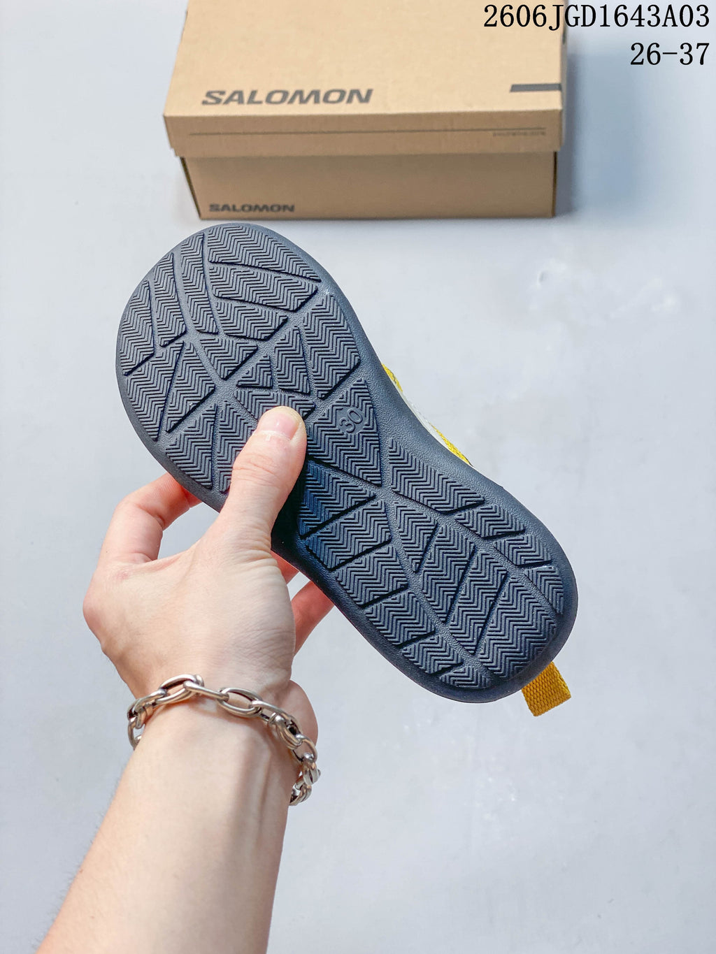 Close-up of the dark geometric tread on a Salomon kids sneaker outsole