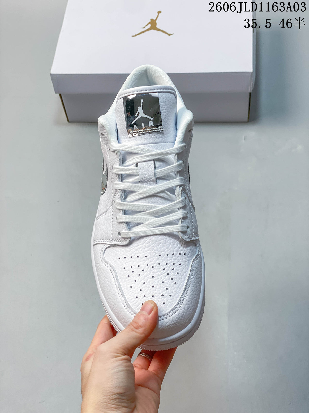 Front view of a white Jordan Air Jordan 1 SE low-top sneaker showing its perforated toe and laces.