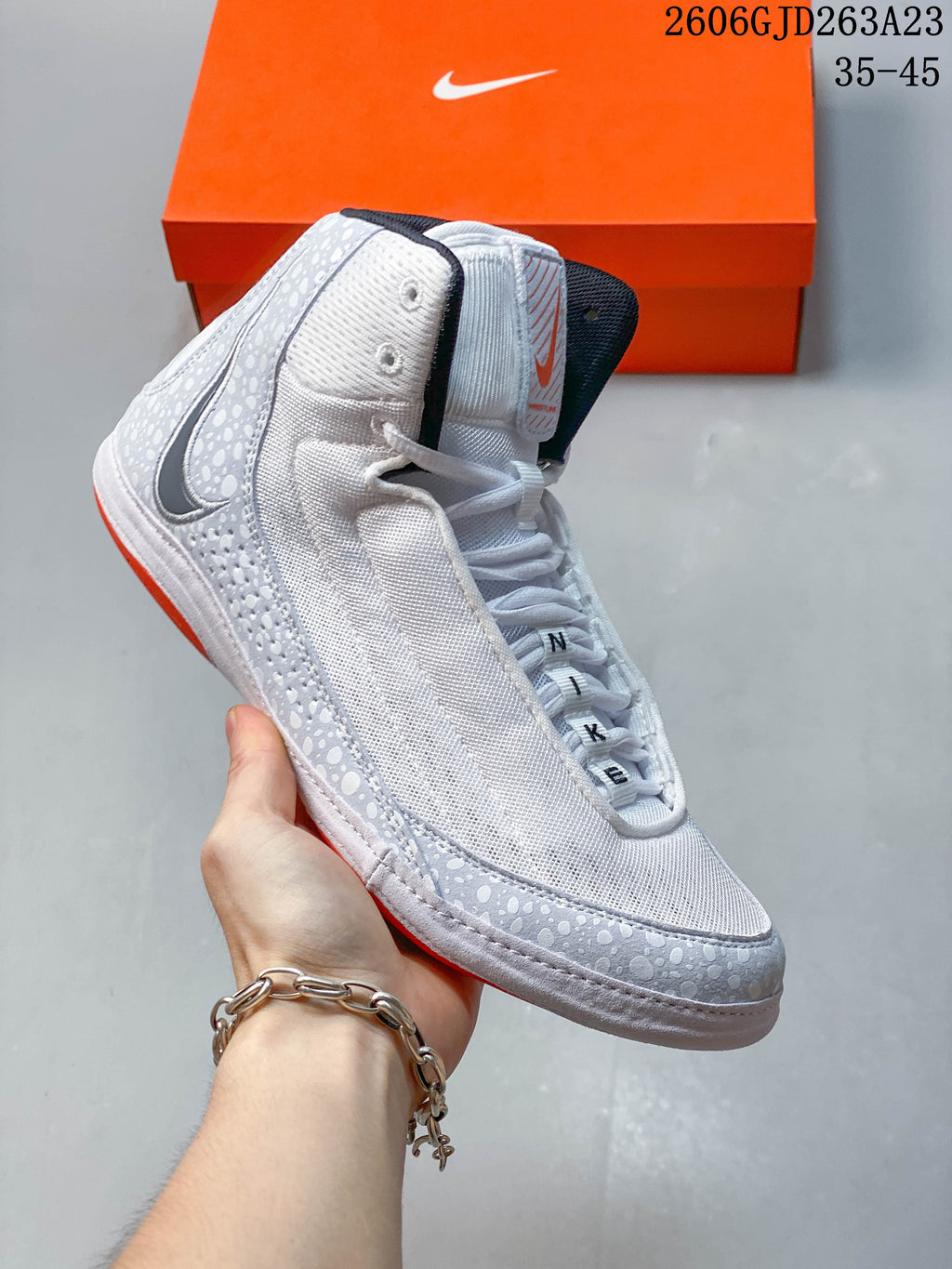Angled side view showing the white and light gray upper, patterned overlays, and black swoosh of a Nike Inflict 4 shoe.